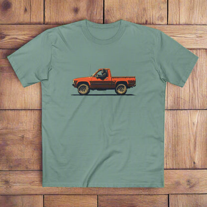 Bigfoot in an orange ute graphic t-shirt printed on a Green AS Colour SageTshirt