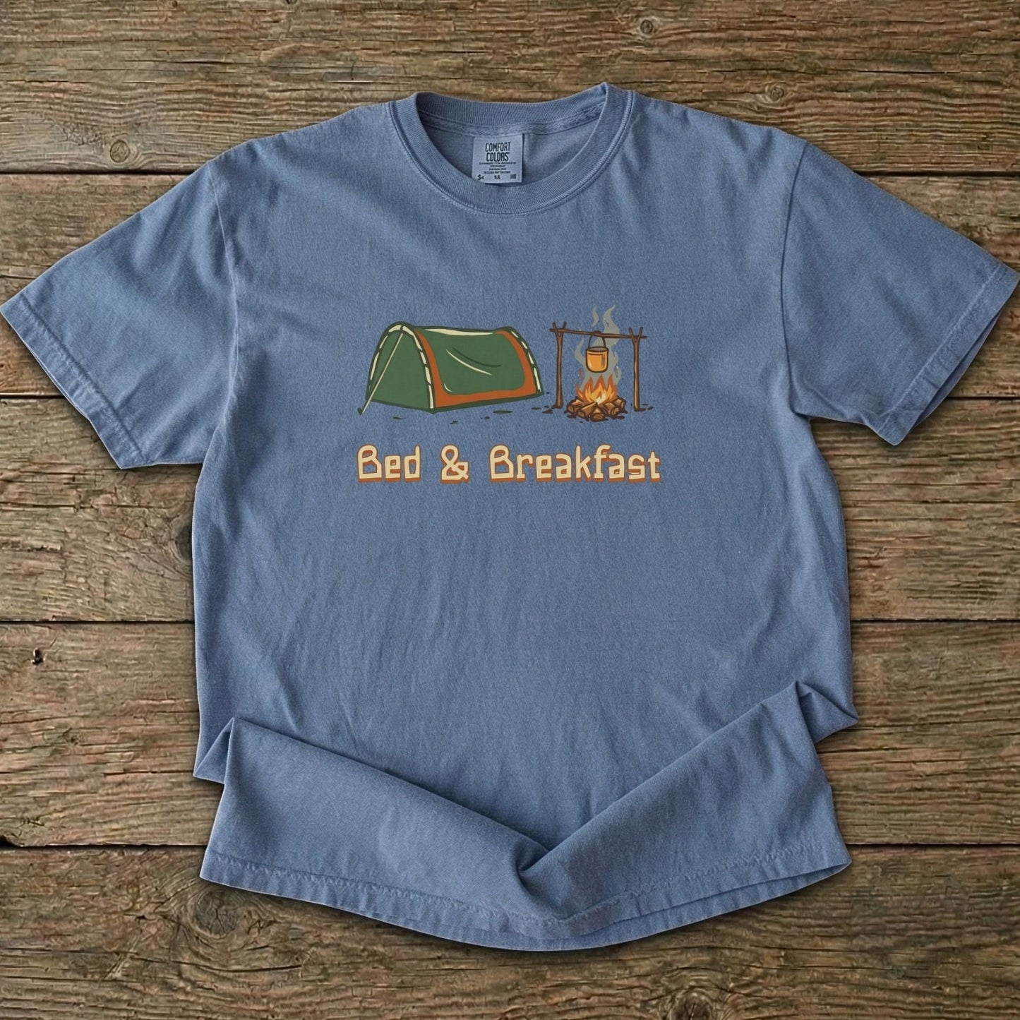 Blue_Jean Tee With Camp and Swag Graphic Print on a wooden background