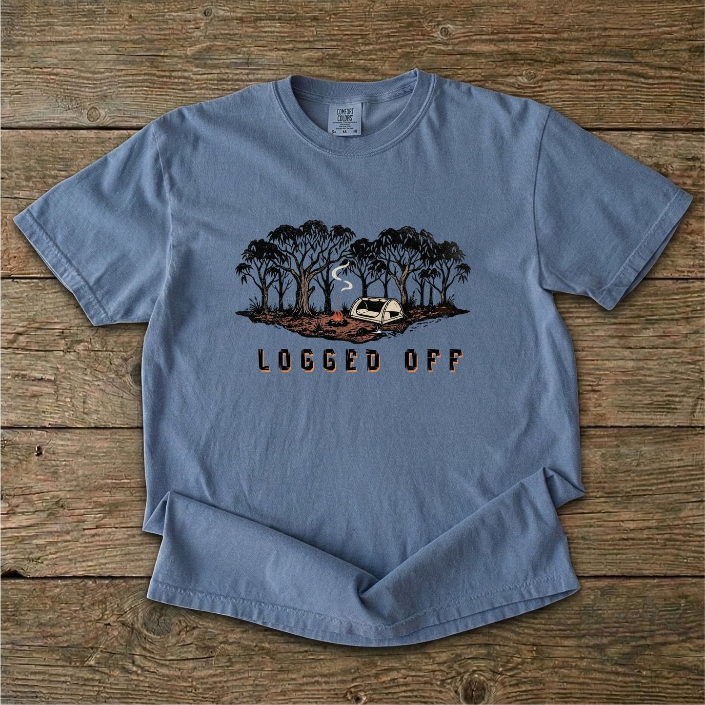 Logged Off camping shirt, t-shirt with a detailed screen-printed design of a smoking campfire and a dome tent nestled among towering Ghost Gums in the Australian bush.