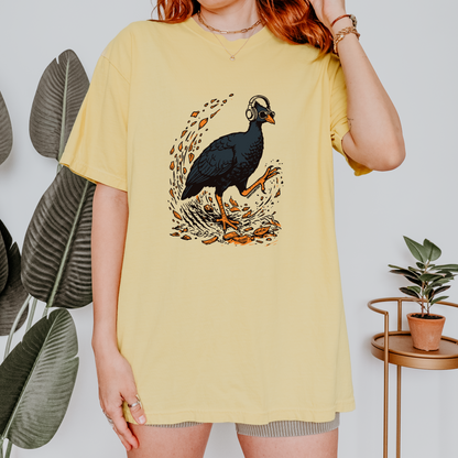 Person wearing a yellow t-shirt with a graphic design of a bush chook bird and headphones.