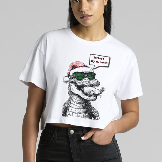 Person wearing a white t-shirt with a Crocodile wearing a christmas hat and sunnies -graphic design on a gray background