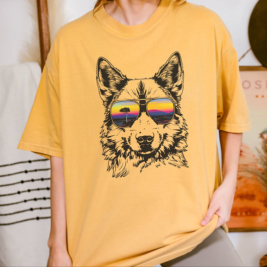 Woman wearing a mustard yellow t-shirt with a graphic of a dingo wearing sunglasses.