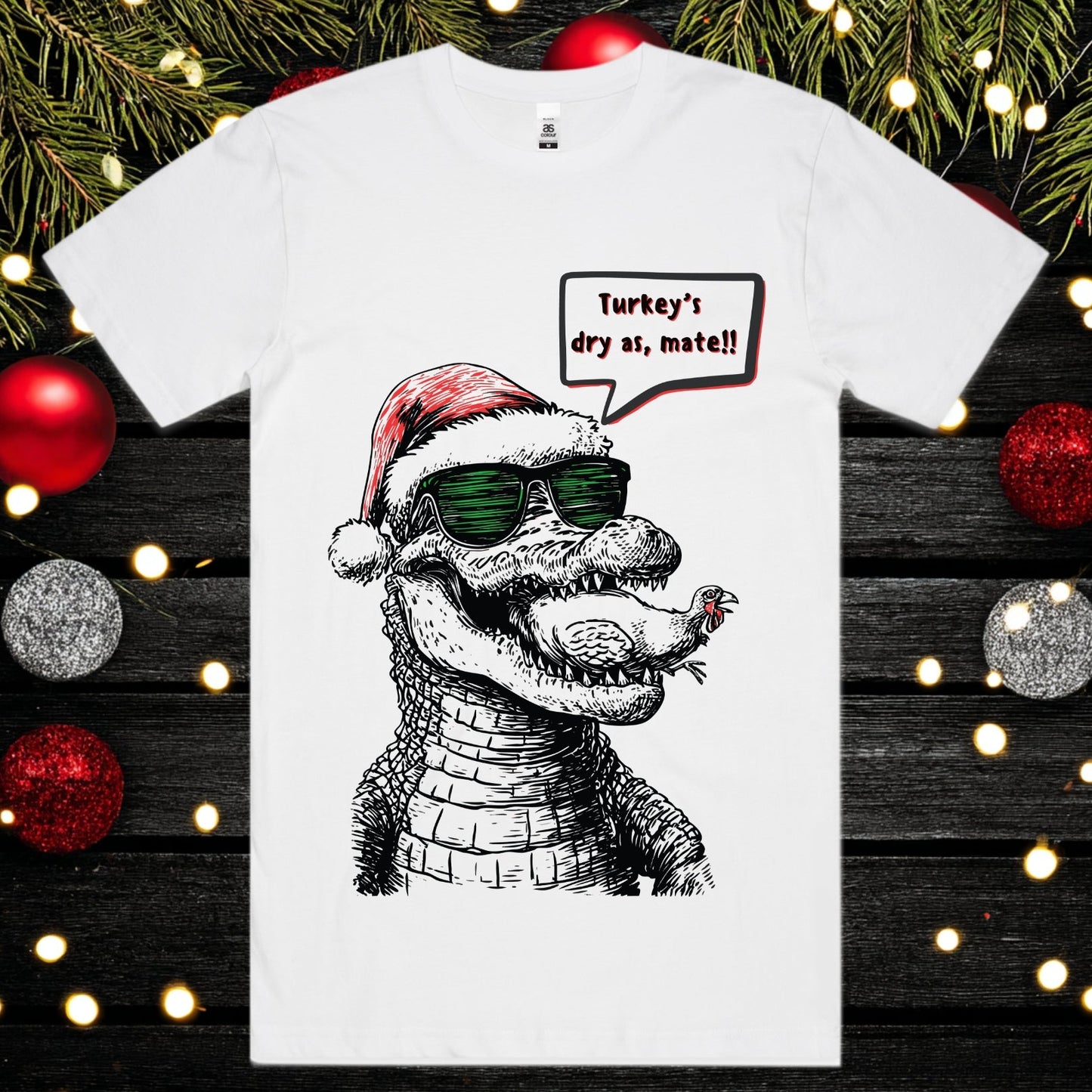 White t-shirt with a crocodile eating a turkey wearing a Santa hat and sunglasses.