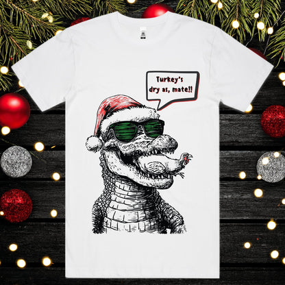 White t-shirt with a crocodile eating a turkey wearing a Santa hat and sunglasses.