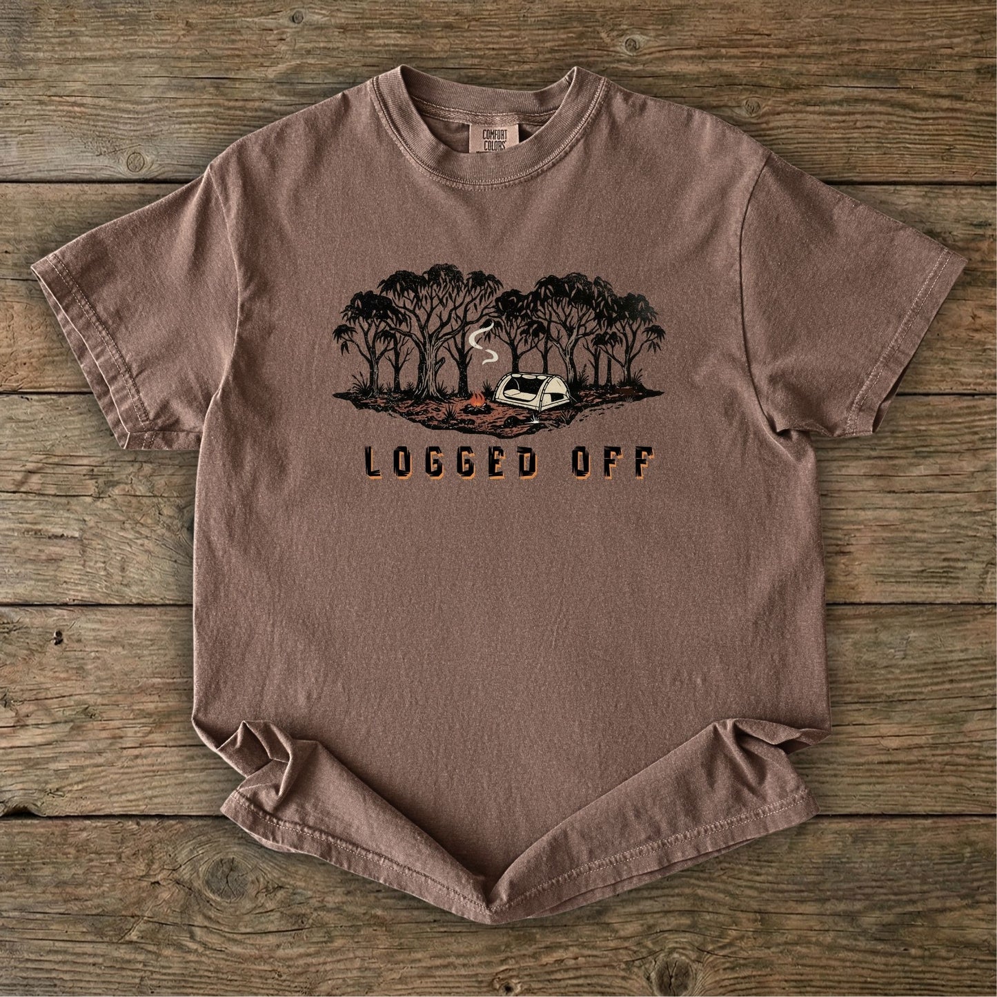 Logged Off camping shirt, t-shirt with a detailed screen-printed design of a smoking campfire and a dome tent nestled among towering Ghost Gums in the Australian bush.