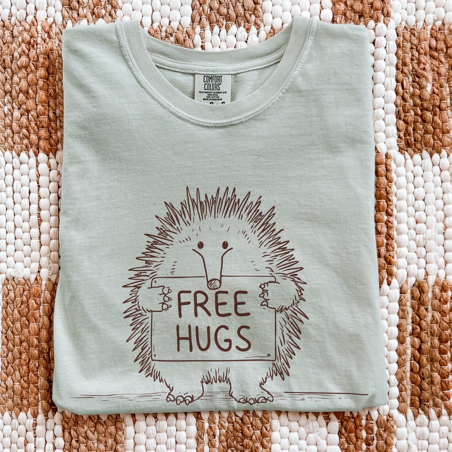 Free Hugs echidna graphic tee on flatlay display