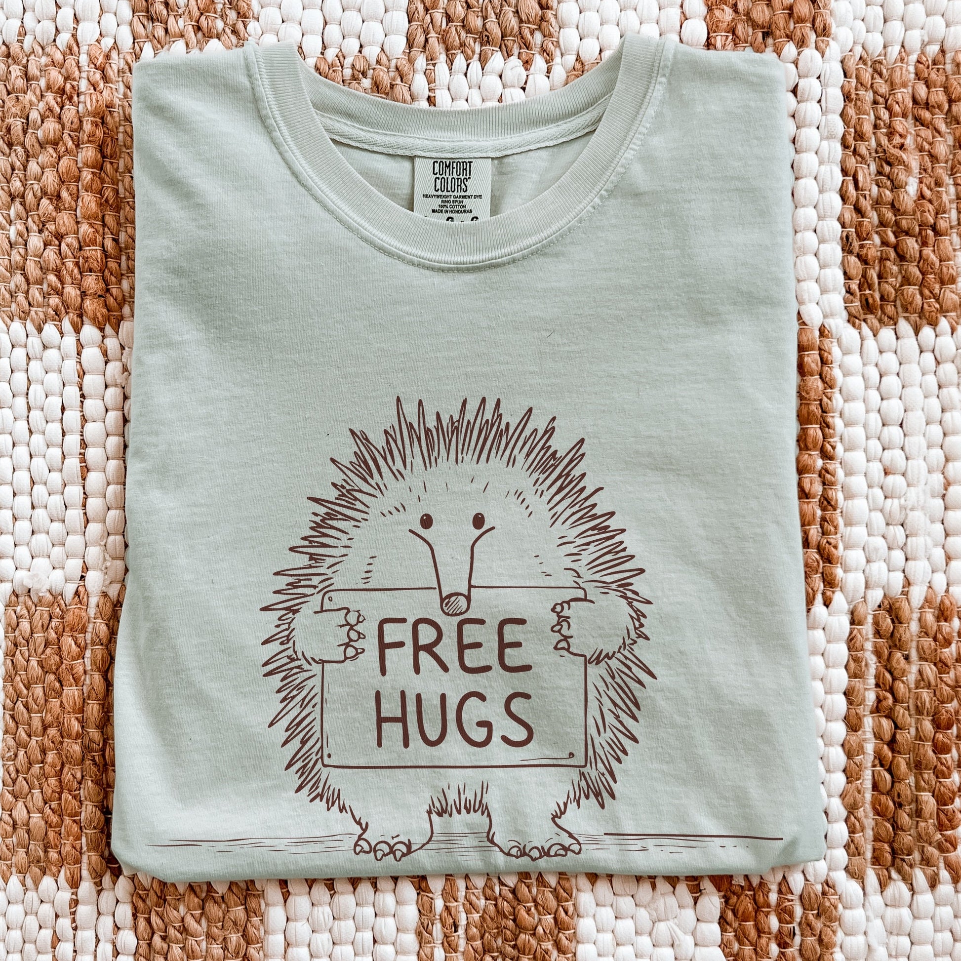Free Hugs echidna graphic tee on flatlay display