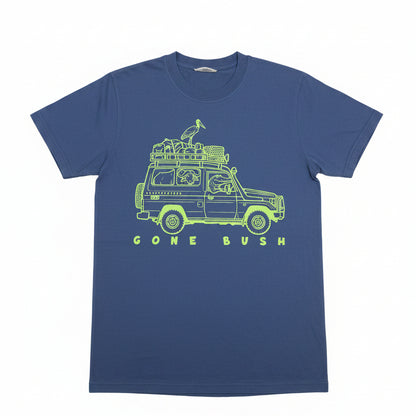 A blue short-sleeve t-shirt with a lime green graphic of a safari jeep carrying a bird on its roof rack, with the text 'GONE BUSH' printed below. The shirt is laid flat on a textured beige background with a paper tag attached to the collar.