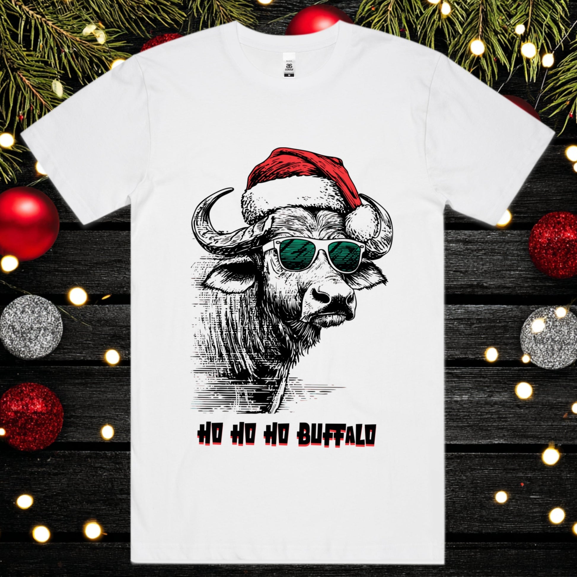 White t-shirt with a buffalo wearing a Santa hat and sunglasses design, surrounded by Christmas decorations.