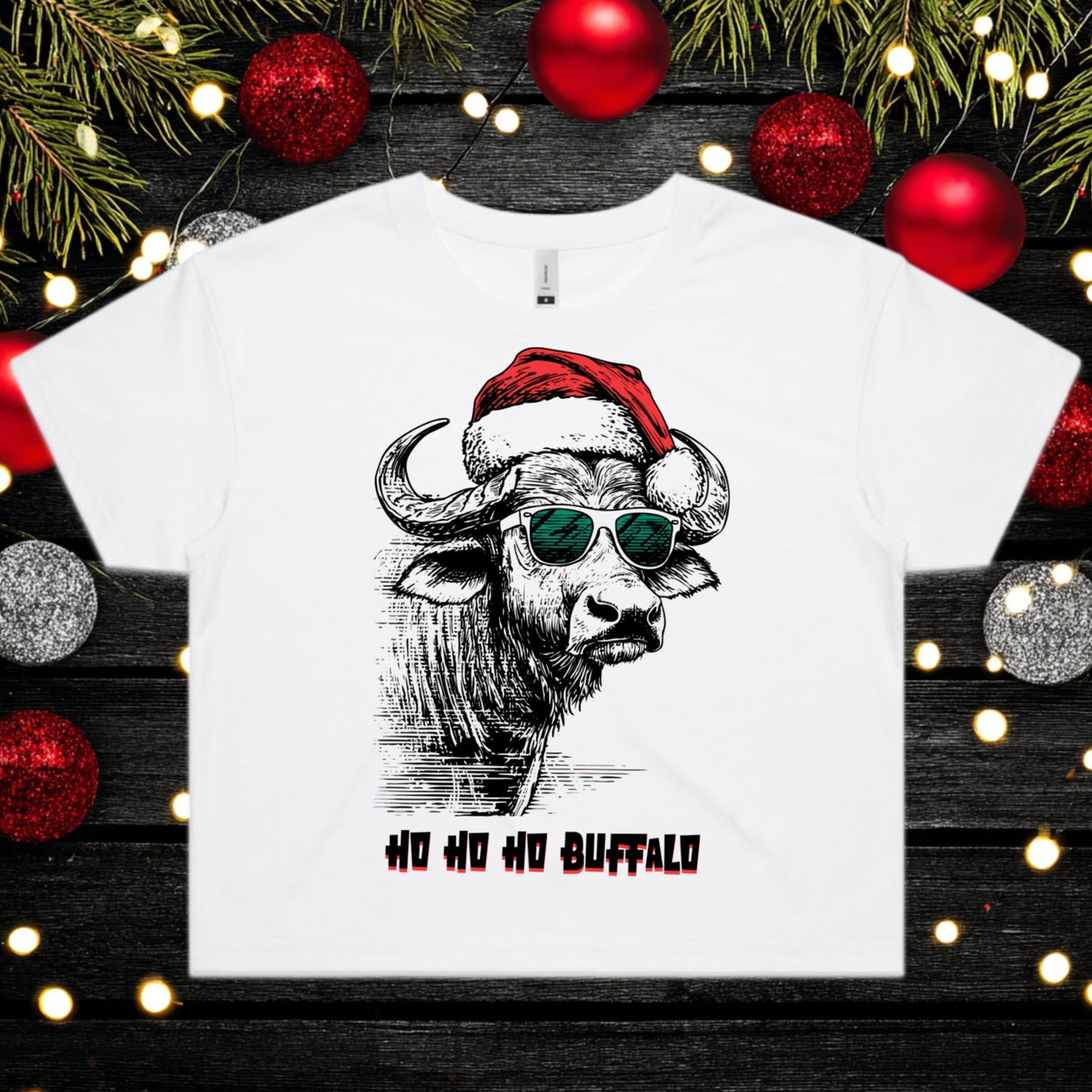 White t-shirt with a buffalo graphic wearing a Santa hat and sunglasses, surrounded by Christmas decorations.