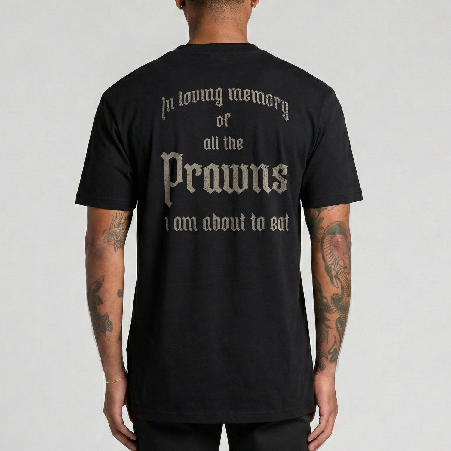 Person wearing a black t-shirt with text on the back, standing against a plain background