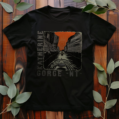 Katherine Gorge T-shirt – black tee with bold line art of a kayak paddling through canyon cliffs at sunrise, featuring orange sky and vertical "Katherine Gorge - NT" text.
