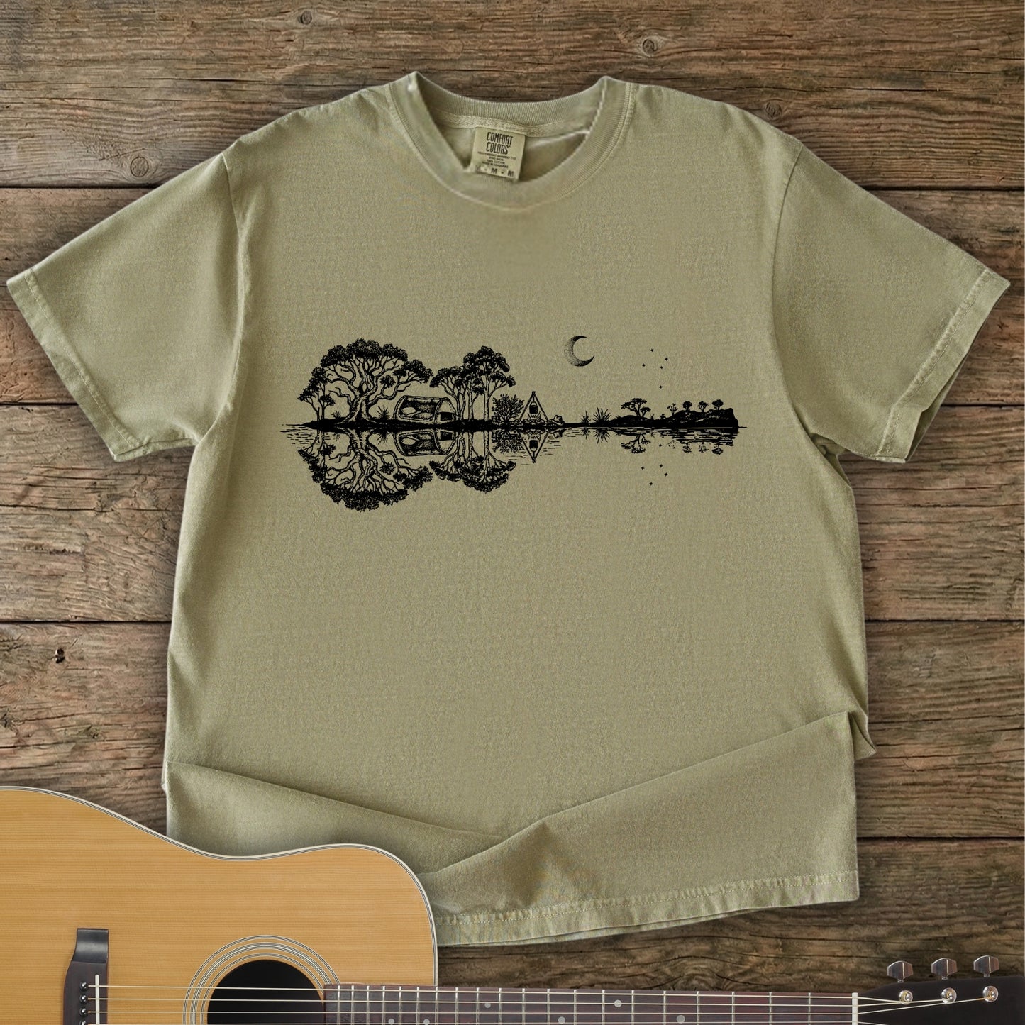 Khaki Colour Southern Stars Guitar Tee featuring a lakeside campsite reflection in a guitar silhouette under an Australian night sky.