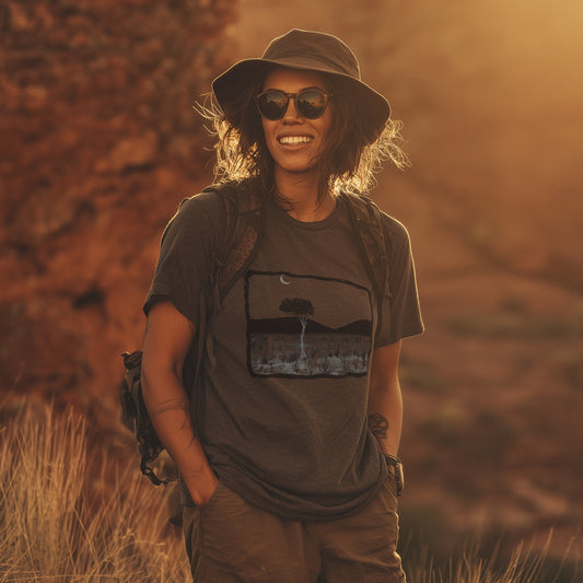 Larapinta walk gum tree and mountain range tshirt worn by a lady in the fading sunlight in central australia