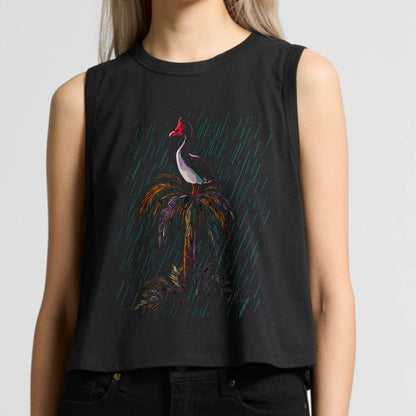 Woman wearing a crop tank top with a magpie goose graphic design on a plain background