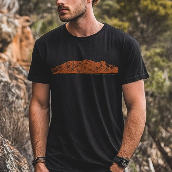 Mt Sonder Larapinta Trail T-shirt – black tee with orange mountain line art, worn by a male hiker in the Australian outback