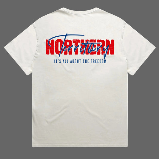 An off-white crewneck t-shirt shown from the back, featuring a graphic print with the word 'NORTHERN' in distressed red block letters and 'Territory' in blue script, with the slogan 'IT'S ALL ABOUT THE FREEDOM' printed below in blue.