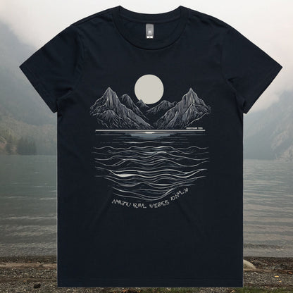 Beautiful print of Mountains and Sea with the text "Natural Vibes Only" printed below on  a navy womens fit T-Shirt. The T-Shirt is Navy and the print is off white. There is a background of mountains and sea.