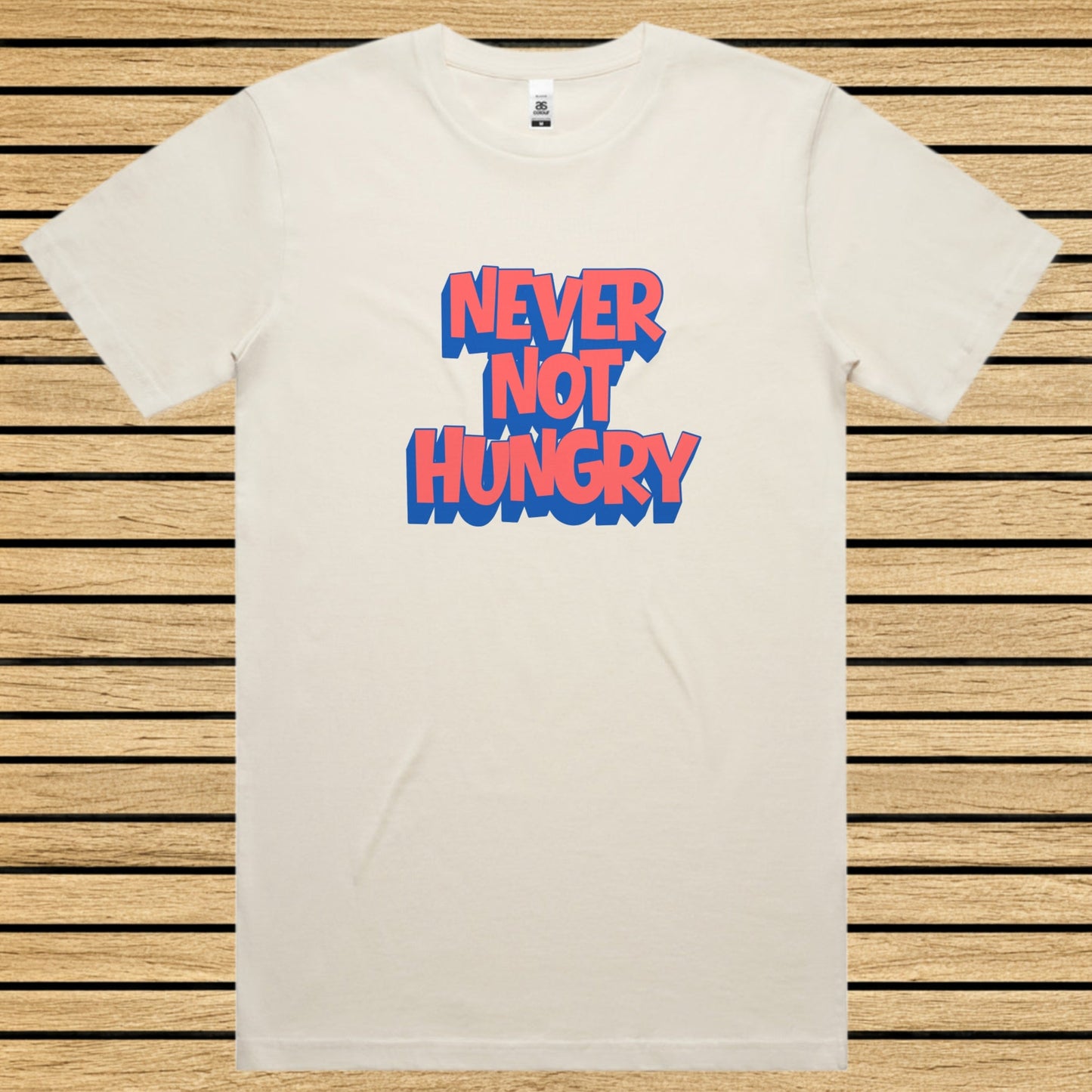 Ecru t-shirt with 'NEVER NOT HUNGRY' text in blue and red on a wooden slat background