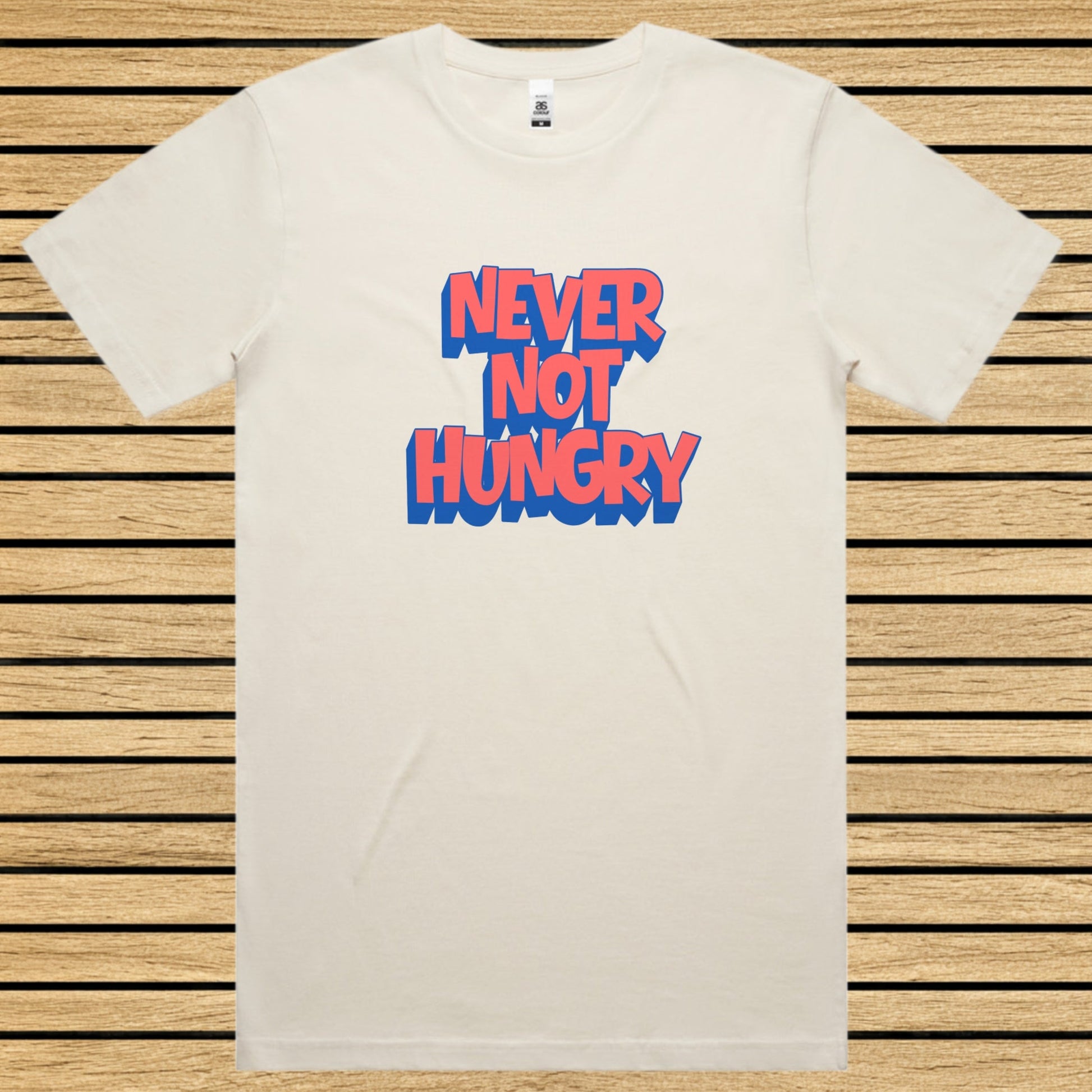 Ecru t-shirt with 'NEVER NOT HUNGRY' text in blue and red on a wooden slat background