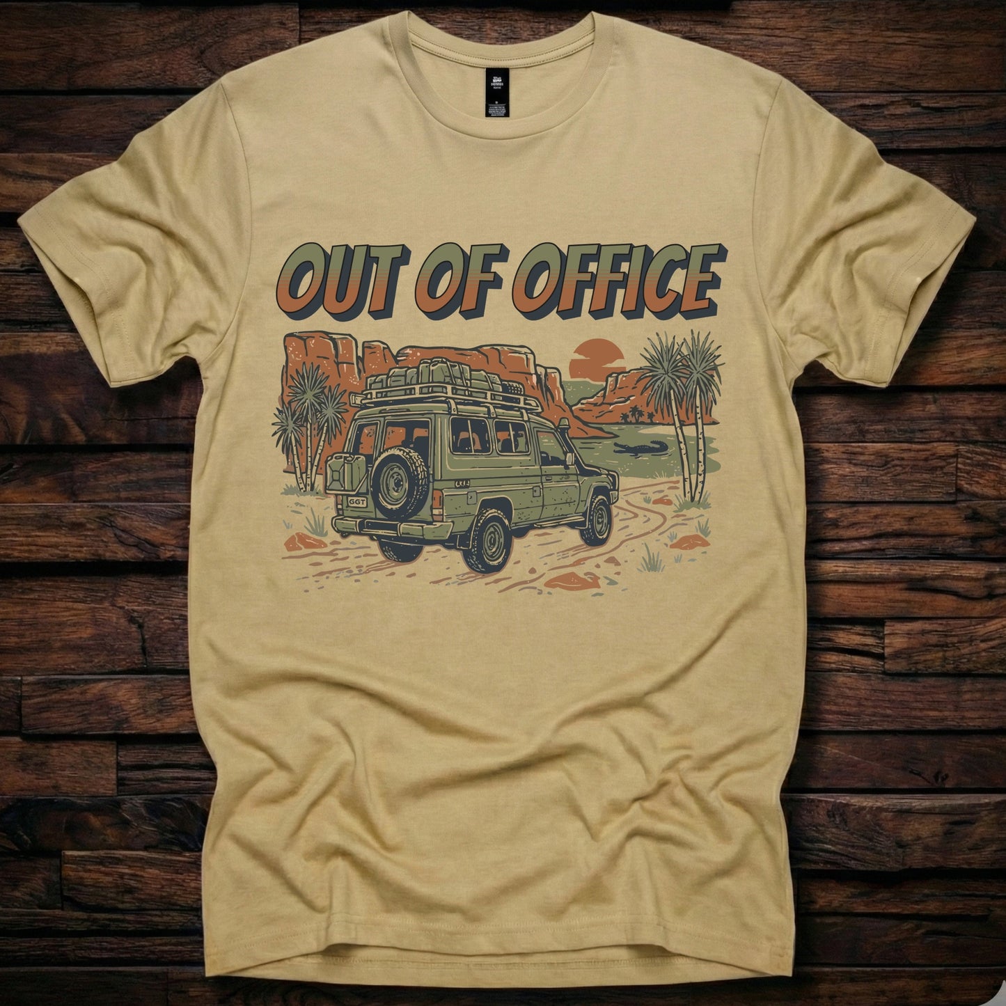 Khaki colour t-shirt featuring a retro 'Out of Office' graphic with a green 4x4 off-road vehicle and Australian outback camping scene on a rustic wooden background.