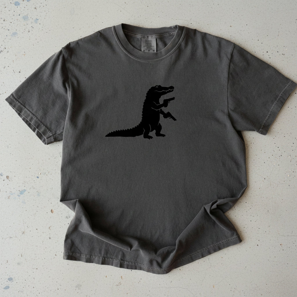A dark gray short-sleeve t-shirt with a black silhouette of a walking alligator printed on the center chest, displayed flat against a white background.