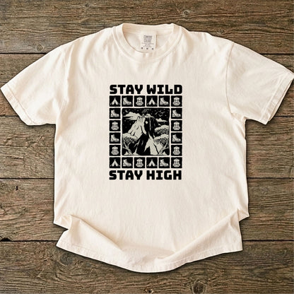 Folded cream-colored t-shirt with 'Stay Wild Stay High' graphic design on a white background