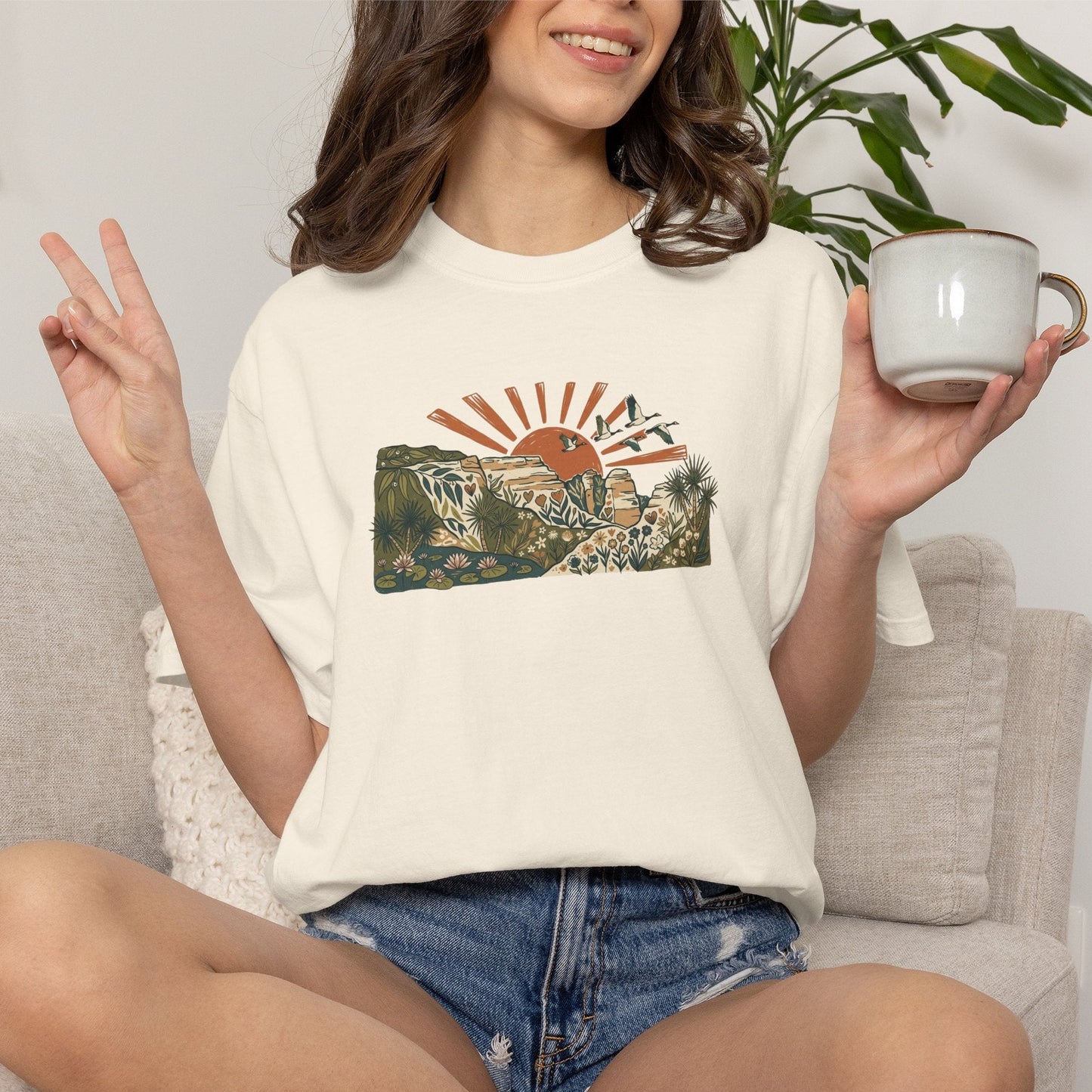 Billabong Sunrise T-shirt featuring an Australian wetland landscape, native plants, rocky escarpment, flying birds and a warm orange sunrise.