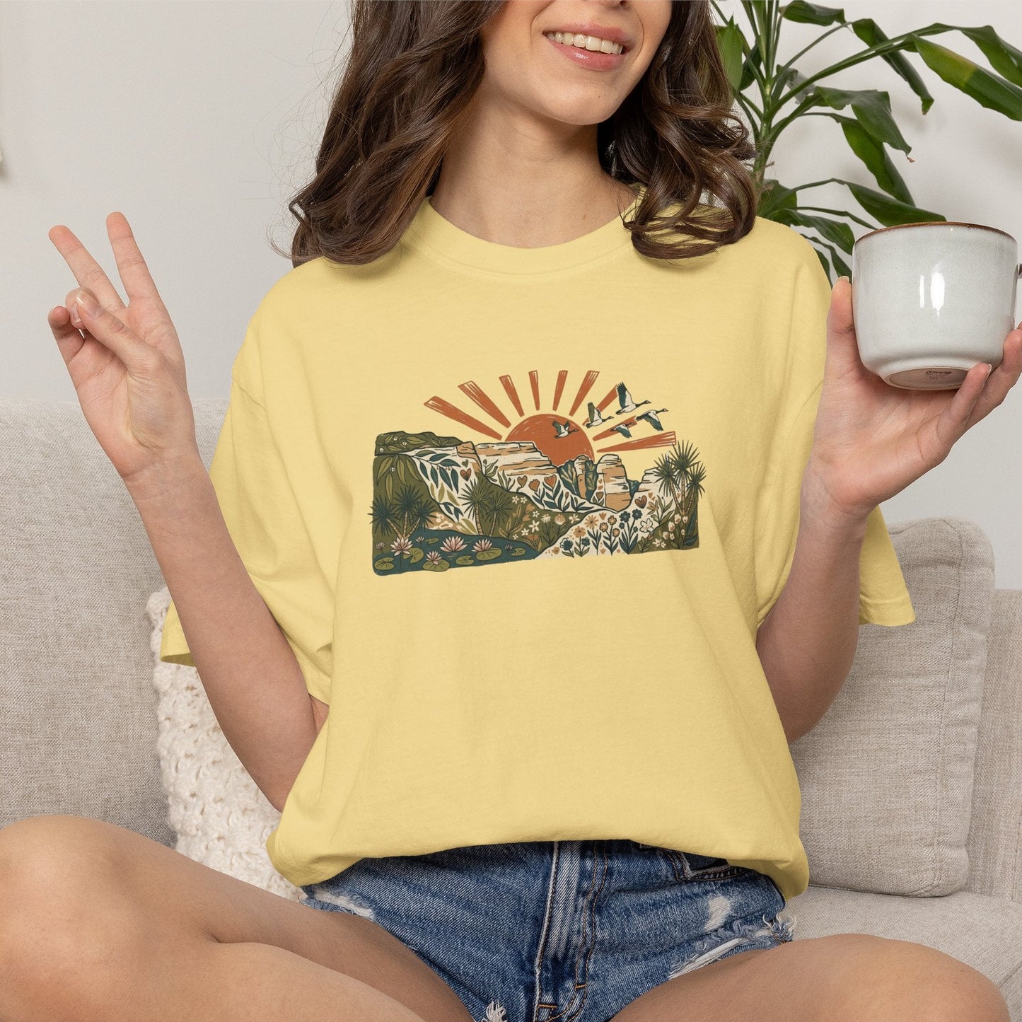 Billabong Sunrise T-shirt featuring an Australian wetland landscape, native plants, rocky escarpment, flying birds and a warm orange sunrise.