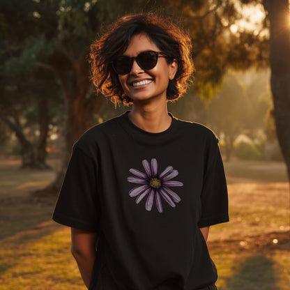 Woman wearing beautiful black wildflower tshirt standing in a park at sunset