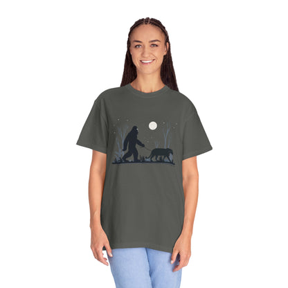 Woman wearing a gray t-shirt with a graphic design of a Yowie Bigfoot and Panther walking under a moonlit sky