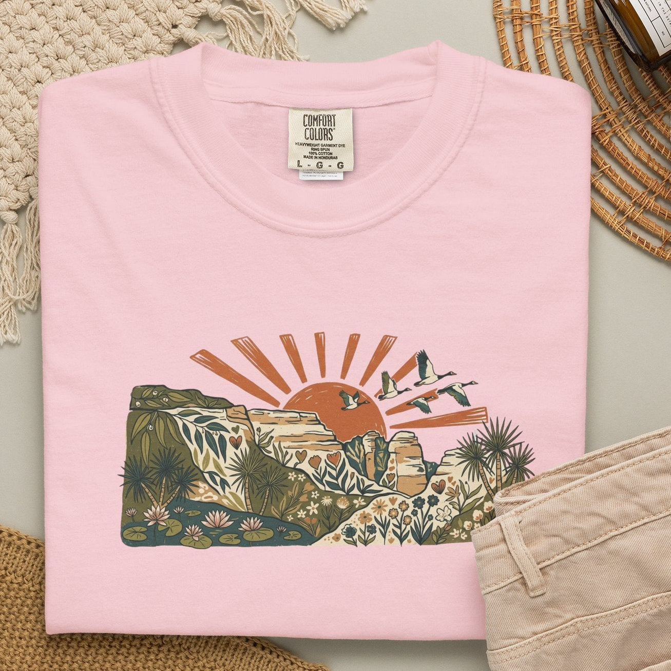 Billabong Sunrise T-shirt featuring an Australian wetland landscape, native plants, rocky escarpment, flying birds and a warm orange sunrise.