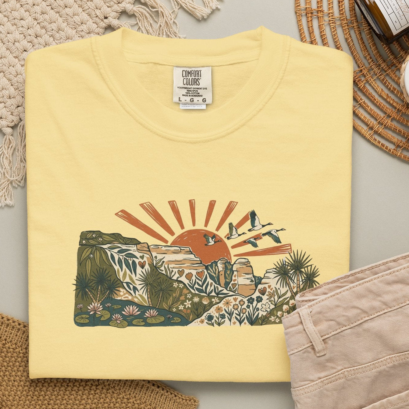 Billabong Sunrise T-shirt featuring an Australian wetland landscape, native plants, rocky escarpment, flying birds and a warm orange sunrise.