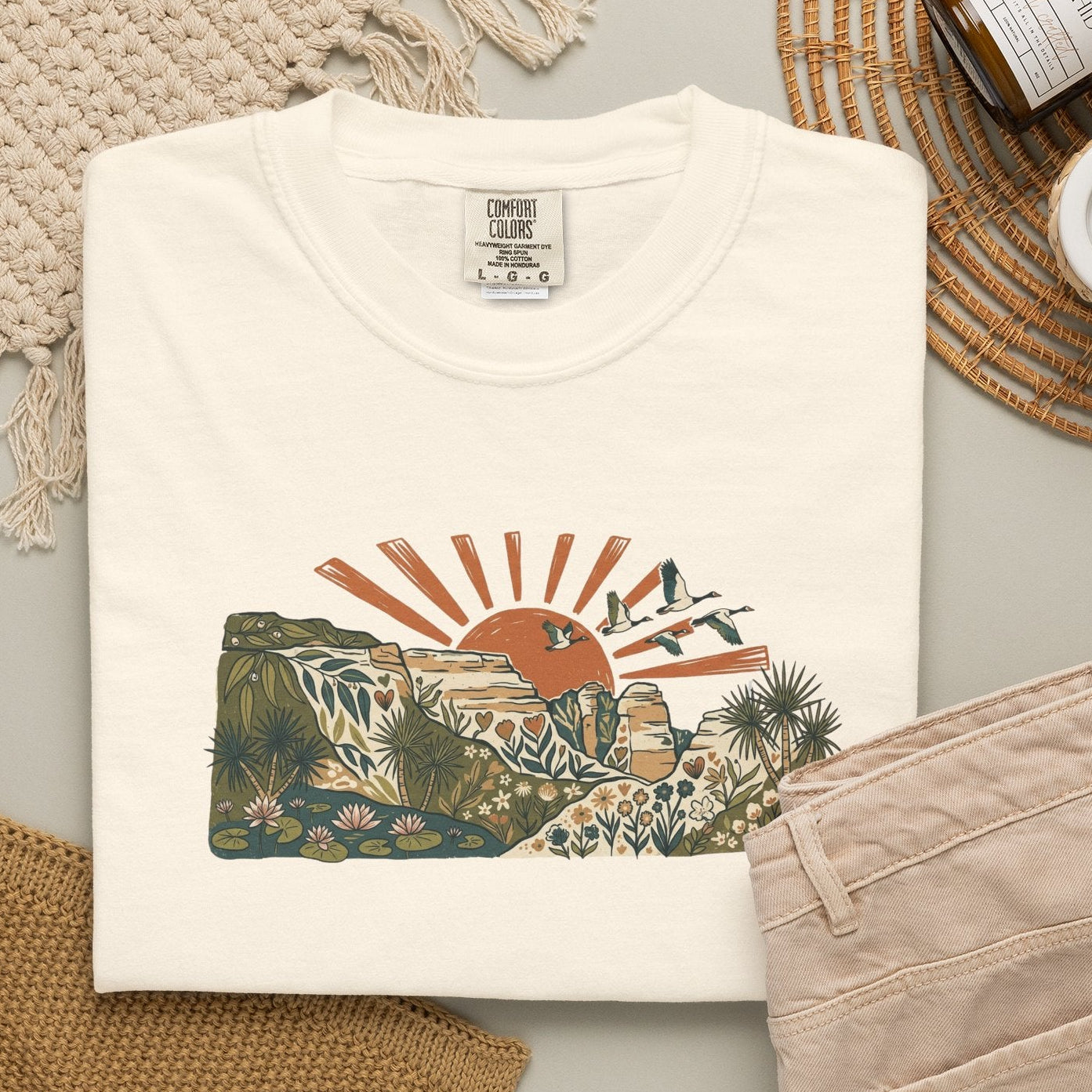 Billabong Sunrise T-shirt featuring an Australian wetland landscape, native plants, rocky escarpment, flying birds and a warm orange sunrise.