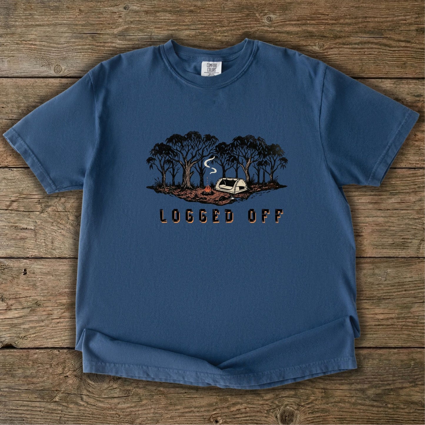 Logged Off camping shirt, t-shirt with a detailed screen-printed design of a smoking campfire and a dome tent nestled among towering Ghost Gums in the Australian bush.