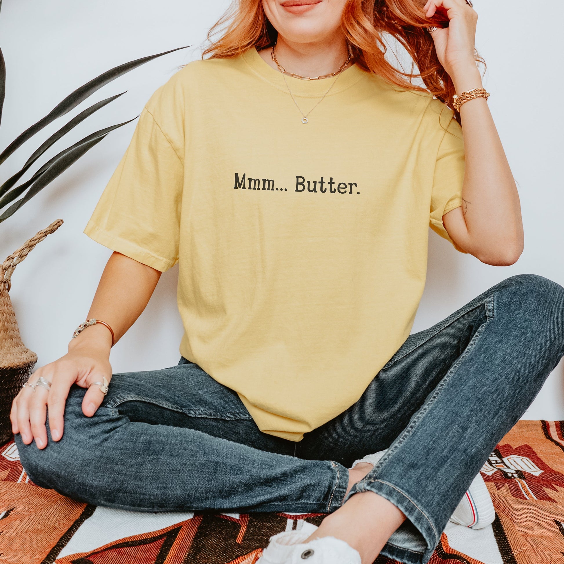 butter yellow vintage wash t-shirt featuring the text Mmm Butter in black. A red haired woman is wearing the tshirt