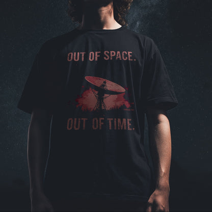 Model wearing a black T-shirt with “Out of Space. Out of Time.” design featuring a satellite dish under a cosmic night sky, moody lighting, space-inspired vibe