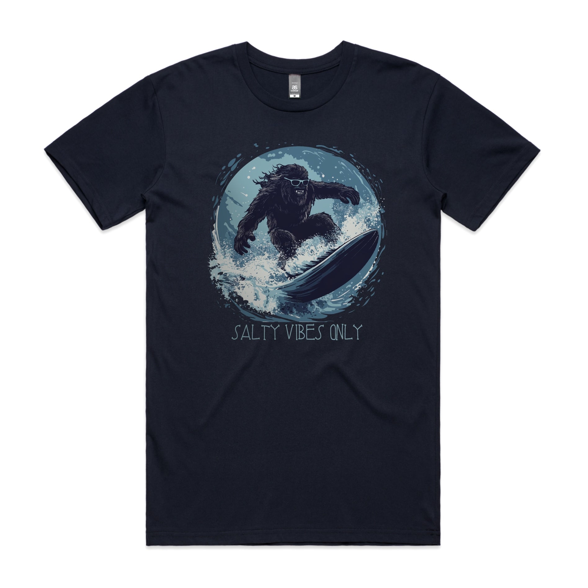 Bigfoot surfing graphic on navy AS Colour Staple Tee with the phrase "Salty Vibes Only" – surf-inspired bigfoot design